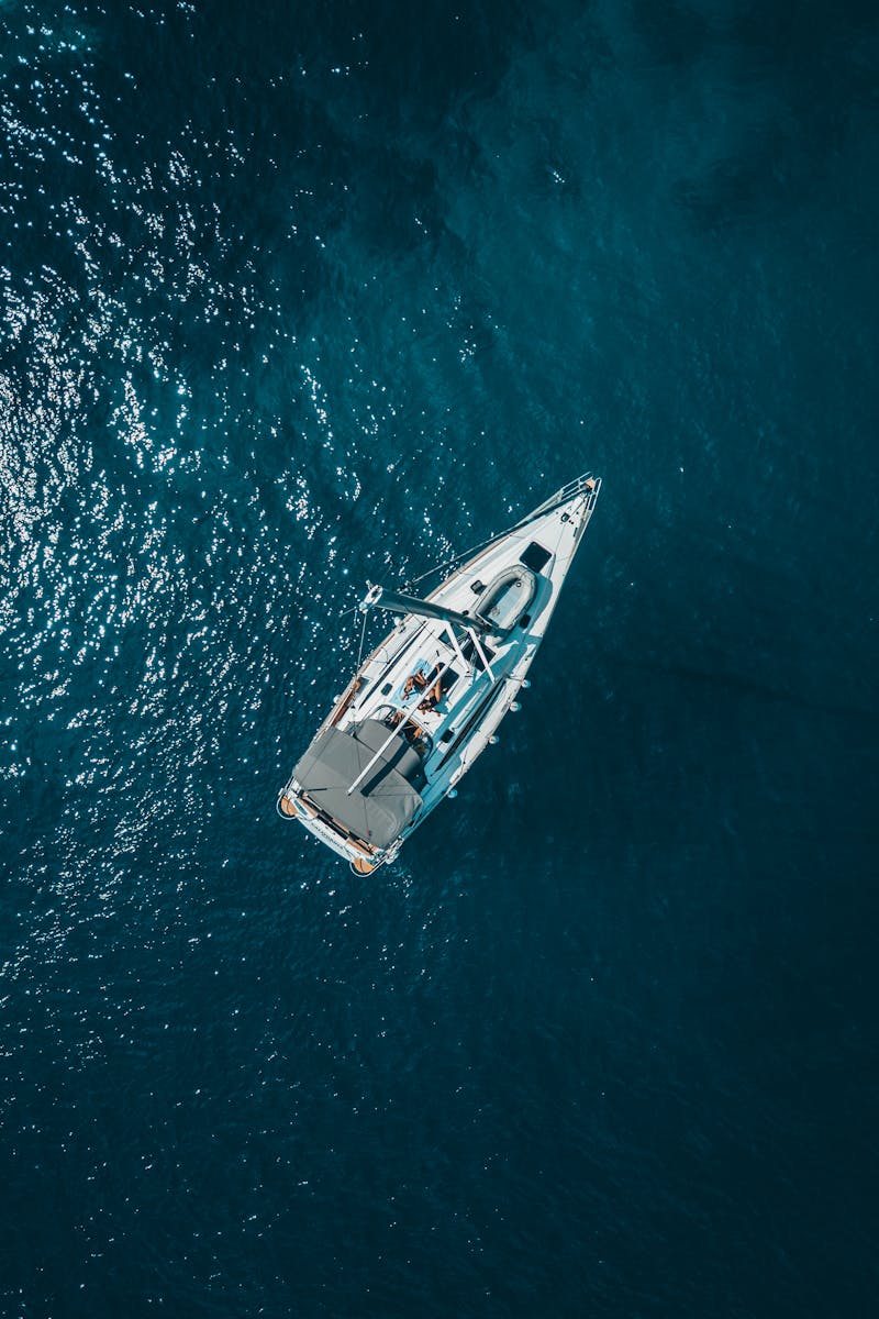 A stunning aerial shot of a sailboat cruising the deep blue waters of Croatia.